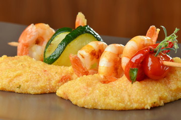 Spicy chili prawn skewers on corn polenta © Visionsi