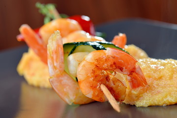 Spicy chili prawn skewers on corn polenta