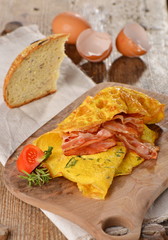 Breakfast omelette with ham, bacon and vegetables close up