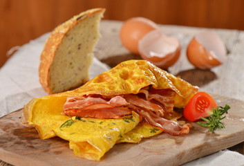 Breakfast omelette with ham, bacon and vegetables close up