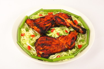 Tandoori chicken on plate with fresh vegetables