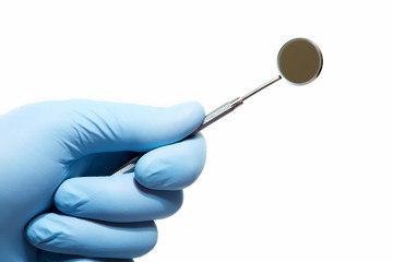 Hand with professional dental tools.