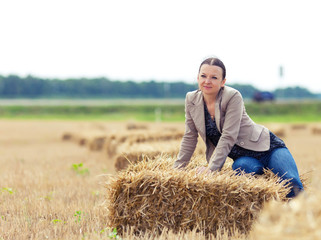 portrait of nice girl with a straw on a field