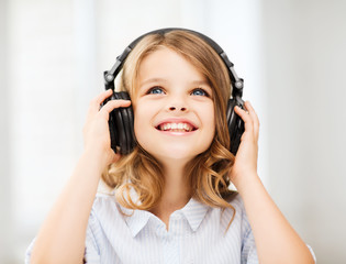 little girl with headphones at home