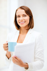 woman with cup of coffee and folders