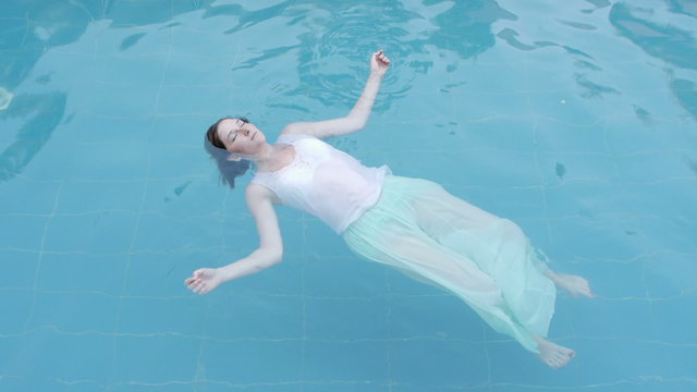 drowned woman body floating in a swimming pool facing up