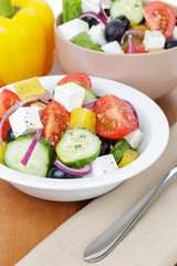 fresh greek salad in white bowl