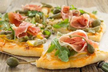 Pizza with arugula and prosciutto.