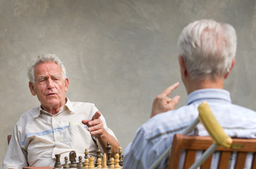 Pensioners talking and playing chess