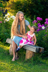 Beautiful blond young girl with her little sister in the country