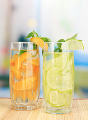 Glasses of fruit drinks with ice cubes on table in cafe
