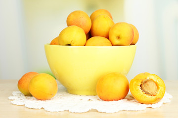 Fresh natural apricot in bowl on table in kitchen
