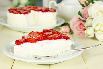 Cheesecake with fresh strawberry on white plate on wooden table