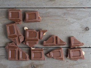 Many chocolate pieces on brown background.  Top view