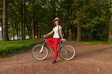 Fototapeta premium Hipster beautiful girl on a bicycle in the park