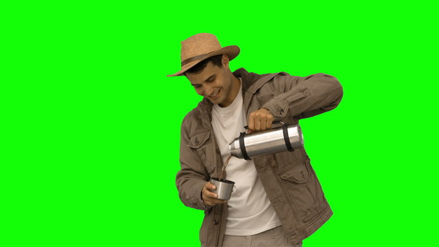 Man pouring coffee from a vacuum flask on green screen