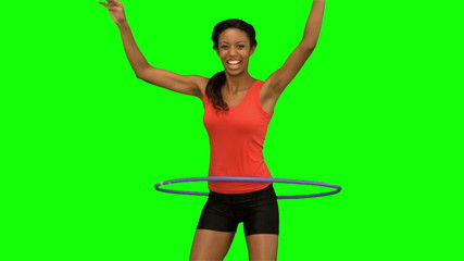 Woman playing with a hula hoop on green screen - Powered by Adobe