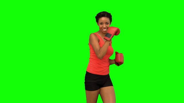 Woman performing air kick on green screen