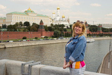 A woman is standing on the background of the Moscow Kremlin