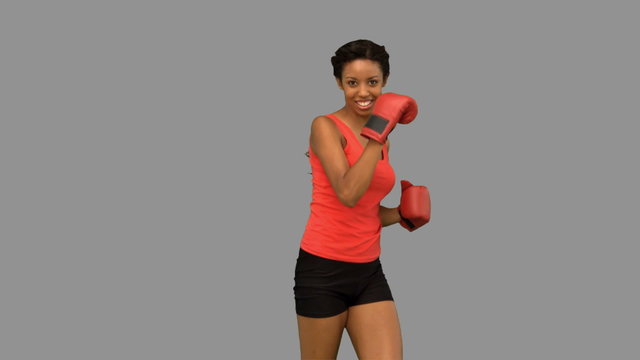 Woman performing air kick on grey screen