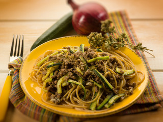 spaghetti with ragout and zucchinis, selective focus