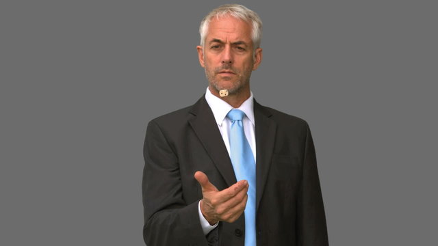 Elegant businessman throwing a dice in the air on grey screen