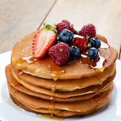 Pancakes with berries and honey closeup
