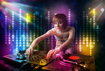 Fototapeta na wymiar Dj girl playing songs in a disco with light show