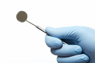 Hand with professional dental tools.