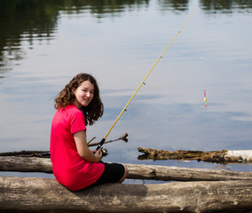 Young girl relaxing while fishing the lake