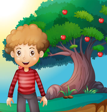 A boy standing in front of the apple tree