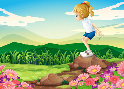 A young girl playing at the hilltop with rocks and a garden