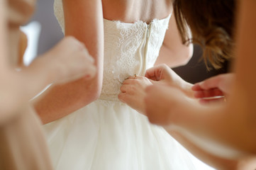 Helping the bride to put her wedding dress