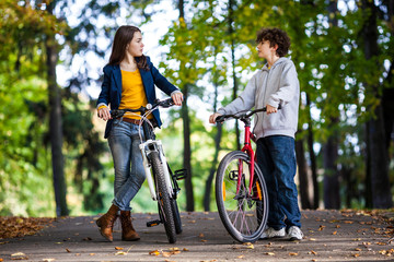 Naklejka premium Urban biking - teens riding bikes in city park