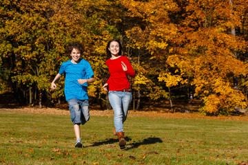 Obraz premium Girl and boy running, jumping in park