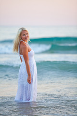 Fototapeta na wymiar Beautiful girl in white dress in the sea