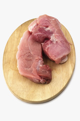 Raw pork ham on wooden cutting board on white background