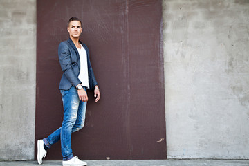 Portrait of  a beautiful young man outdoors against a wall
