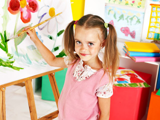 Child painting at easel.