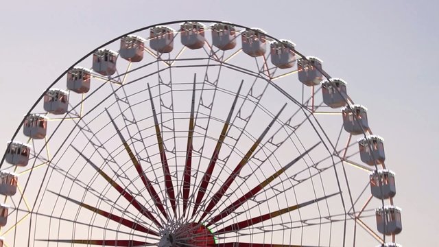 Noria de feria girando al atardecer con luces de neon