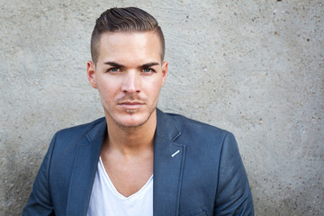 Portrait of  a beautiful young man outdoors against a wall