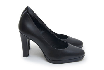 Close-up of female high-heeled shoes over white background