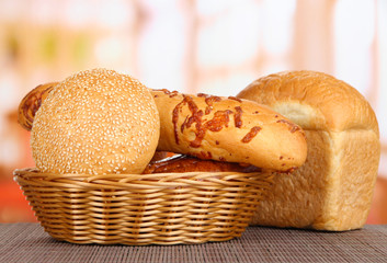 Baked bread in wicker basket on window background