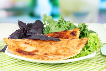 Tasty chebureks with fresh herbs on plate,on  bright background