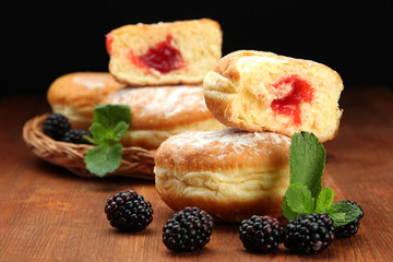 Tasty donuts with berries on wooden table