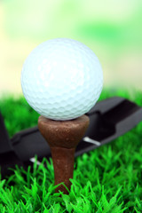 Golf ball and driver on green grass outdoor close up