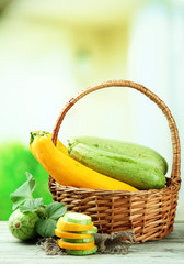 Sliced and whole raw zucchini in wicker basket, outdoors