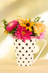 Beautiful bouquet of bright flowers in color mug,