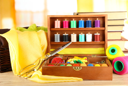 Sewing kit in wooden box with books and cloth table