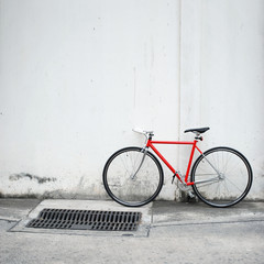 Fototapeta na wymiar Nowoczesny rower czerwony oparty na białej ścianie